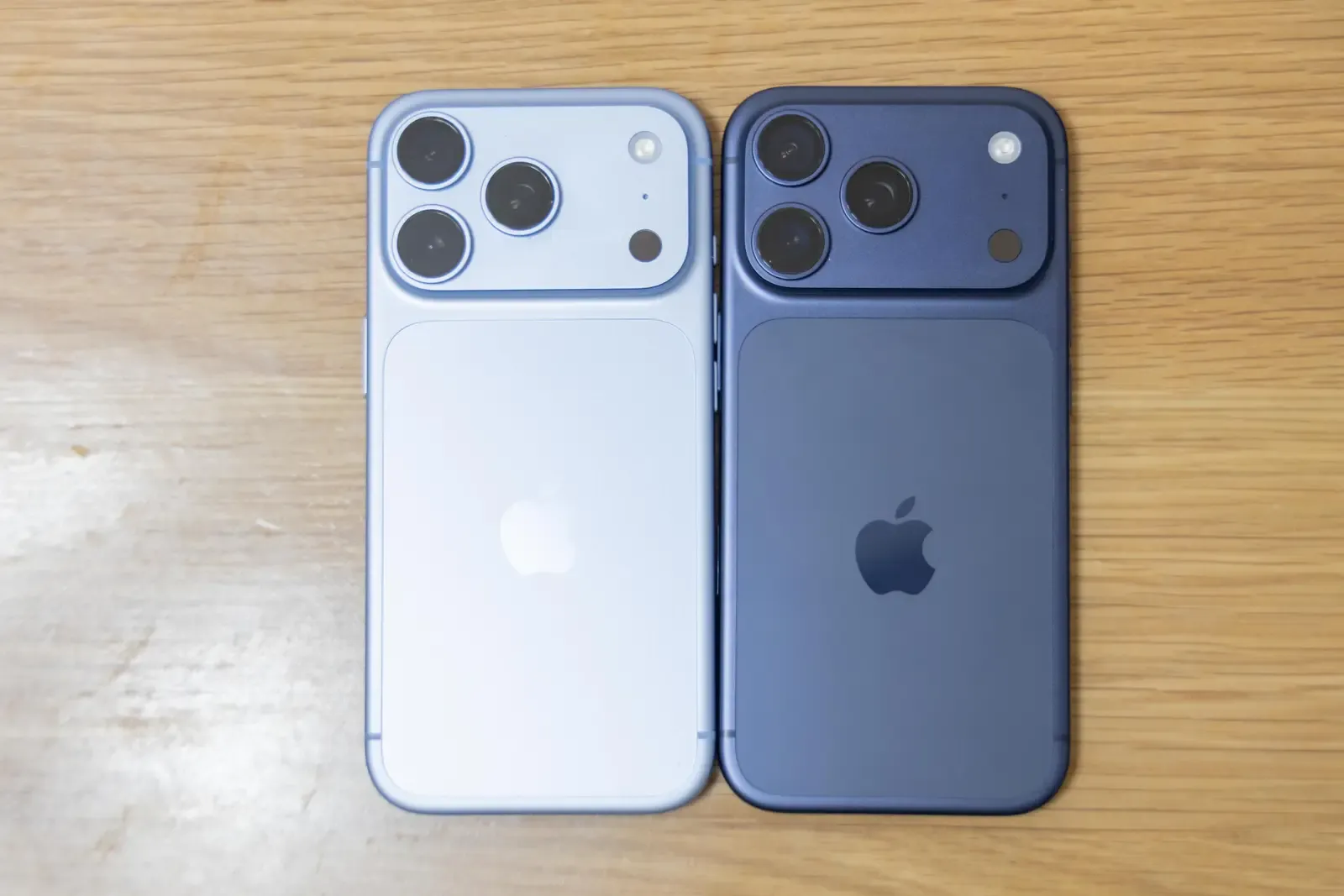 iPhone 18 Pro（左・グレイシャー）とiPhone 17 Pro（右・ディープブルー）を背面から並べた比較。3眼カメラの配置は同じ